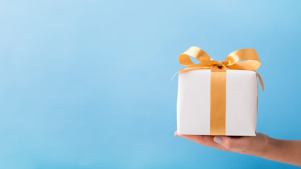 Creative Christmas gift with golden ribbon on woman palm