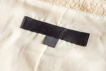Blank black laundry care clothing label on fabric texture