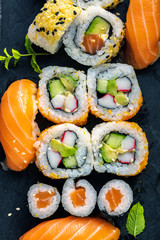top view of delicious sushi set on slate board and chopsticks