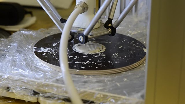 Turin, Piemonte, Italy. October 2019. At a coworking tool box a 3D printer demo and ceramic extrusion. The head deposits small amounts of material with rapid movements. Selective focus.