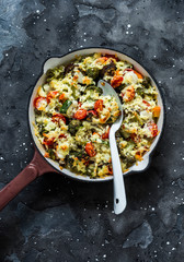 Vegetarian casserole ratatouille, baked in a frying pan on a dark background, top view