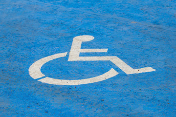 Handicap parking sign painted on road on parking space for disabled or handicapped people in parking lot