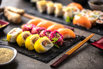  Sushi Set Sashimi und Sushirollen auf Steinschiefer serviert