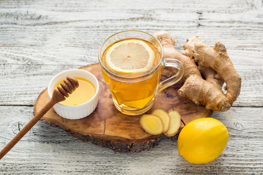 Ginger tea with lemon and honey on a white wooden background. Hot healthy winter drink