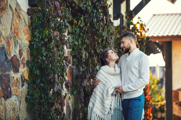 Beautiful and happy young couple man and woman in a beautiful garden in the yard of a country house