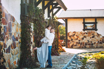 Beautiful and happy young couple man and woman in a beautiful garden in the yard of a country house