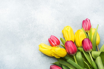 Bouquet of yellow and pink tulips on a light blue background. Copy space