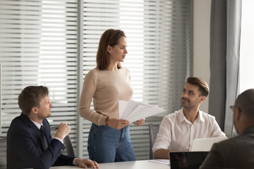 Confident businesswoman holding documents, mentor training staff at briefing