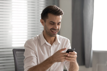Happy businessman employee holding phone, using mobile device app