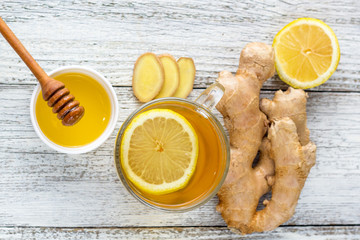 Ginger tea with lemon and honey on a white wooden background. Hot healthy winter drink