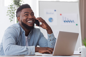 Happy african american employee received good news on phone