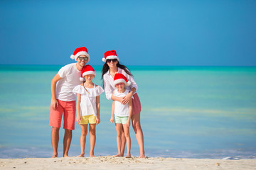 Happy family with two kids in Santa Hat on summer vacation