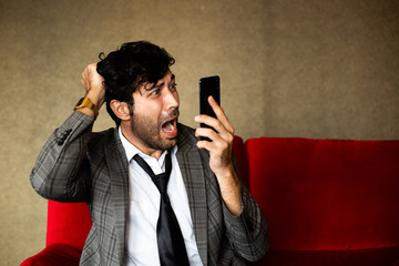 Business man with funny and crazy face action with mobile phone