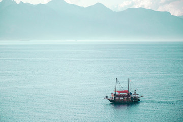 Fototapeta premium Boat with passengers. Boat trips and excursions concept. Mountains on the background.