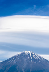 Mount Fuji with cloudy hat on top , vertical close up with amazing clouds on blue sky background, beautiful in morning time in Fujinomiya, Shizuoka ,Japan