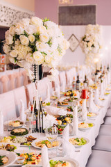 The decor of the wedding dinner. Wedding table setting. Dishes on the table in a restaurant.