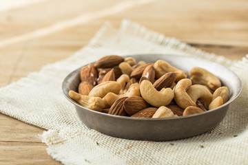 Nuts Mixed in a wooden plate.Assortment, Walnuts,Pecan,Almonds,Hazelnuts,Cashews,Pistachios.Concept of Healthy Eating.Vegetarian.selective focus.