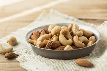 Nuts Mixed in a wooden plate.Assortment, Walnuts,Pecan,Almonds,Hazelnuts,Cashews,Pistachios.Concept of Healthy Eating.Vegetarian.selective focus.