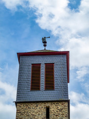 Church of St. Remigius bell tower with angle with trumpet decoration in the village Pronsfeld, District of Bitburg-Pruem, in Rhineland-Palatinate, Western Germany