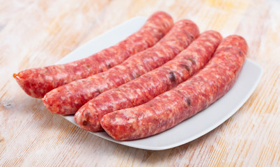 Uncooked sausages on wooden table