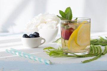 Infused water made from blueberry strawberry and lemon in sparkling mineral water look so freshness and healthy. Mixed fruit mojito on wood table with copy space. Summer refreshing drink concept. Ice 