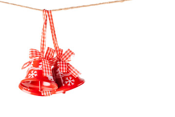 Isolated red Christmas bells with craft ribbons hanging on a jute rope. Christmas and New Year holidays celebration concept with copy space.