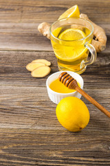 Ginger tea with lemon and honey on a wooden background. Hot healthy winter drink