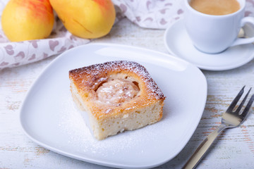 Mannik (Semolina pie) with pear and canella. In the background is a cup of coffee and fresh pears. Traditional Russian cuisine. Close-up, selective focus.