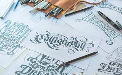 Typography Calligraphy artist designer drawing sketch writes letting spelled pen brush ink paper...