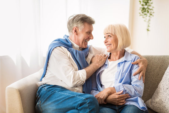 Excited senior couple talking and relaxing at home