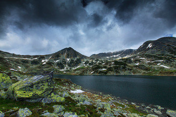 Beautiful scenery in the Alps, in June, with spring flowers and dramatic storm clouds