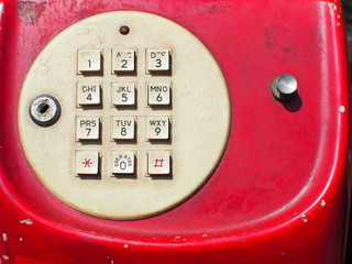 Close up of old retro red phone keypad. Analog dial pad of old phone. Vintage and retro telephone.