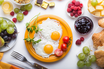 Homemade breakfast with sunny side up fried egg croissant toast coffee fruits vegetable and orange juice in top view with copy space. Delicious homemade american breakfast concept for background. Amer