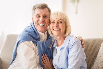 Loving senior couple smiling happily at camera