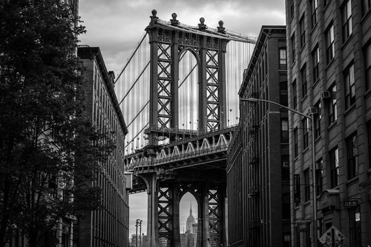 View of one of the towers of the Manhattan Bridge from the streets of the DUMBO district, Brooklyn, NYC black and white © FitchGallery