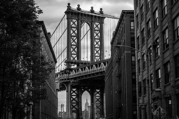 Naklejka premium Widok jednej z wież mostu Manhattan Bridge z ulic dzielnicy DUMBO, Brooklyn, NYC czarno-biały