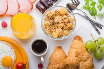 Homemade breakfast with sunny side up fried egg croissant toast coffee fruits vegetable and orange juice in top view with copy space. Delicious homemade american breakfast concept for background. Amer