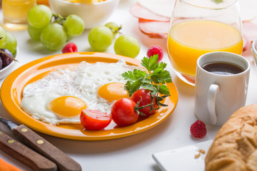 Homemade breakfast with sunny side up fried egg croissant toast coffee fruits vegetable and orange juice in top view with copy space. Delicious homemade american breakfast concept for background. Amer