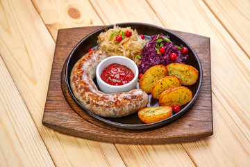 sausage with baked potatoes and salad on the wooden background