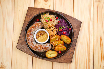 sausage with baked potatoes and salad on the wooden background
