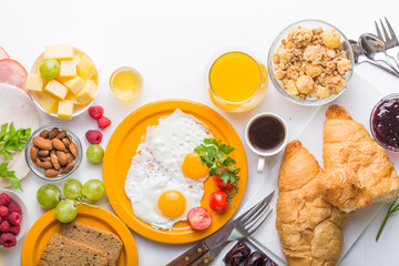 Homemade breakfast with sunny side up fried egg croissant toast coffee fruits vegetable and orange juice in top view with copy space. Delicious homemade american breakfast concept for background. Amer