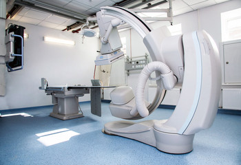 Angiographer in a modern hospital for heart surgery with a remote and monitors