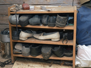 Fototapeta na wymiar Shelf with abandoned old shoes