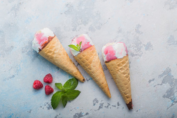 background of three flavored ice cream scoops on cones