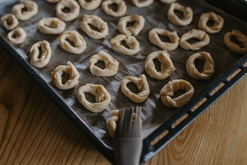 cookies or donut-shaped sweets on the tray prepared for cooking