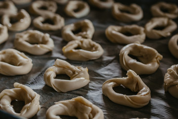 cookies or donut-shaped sweets on the tray prepared for cooking