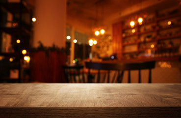 background Image of wooden table in front of abstract blurred restaurant lights