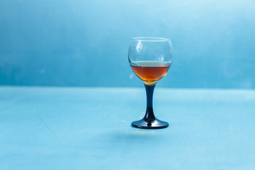 glass of cognac on a blue background