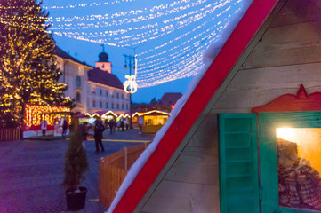 Fototapeta na wymiar Winter magic night image with tourists and Christmas decorations. Winter tale at Christmas Market, largest in Transylvania, Europe