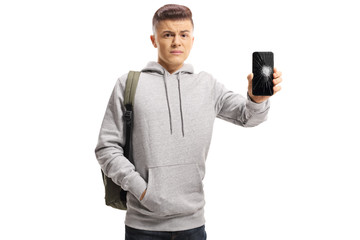 Sad male teenager holding a mobile phone with a broken screen